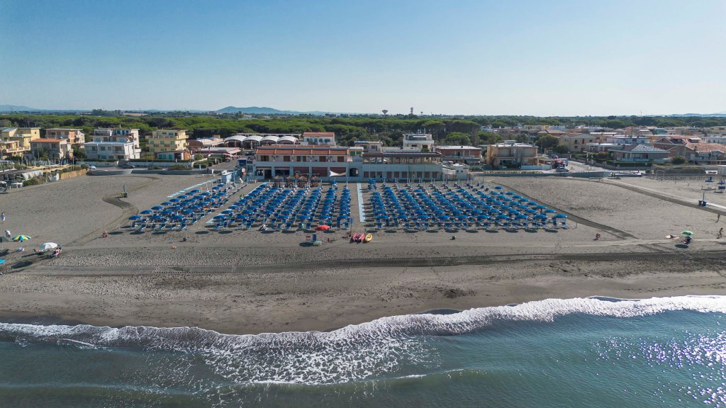 A beach scene with a large number of people enjoying the sun and water, surrounded by a vibrant and lively atmosphere.