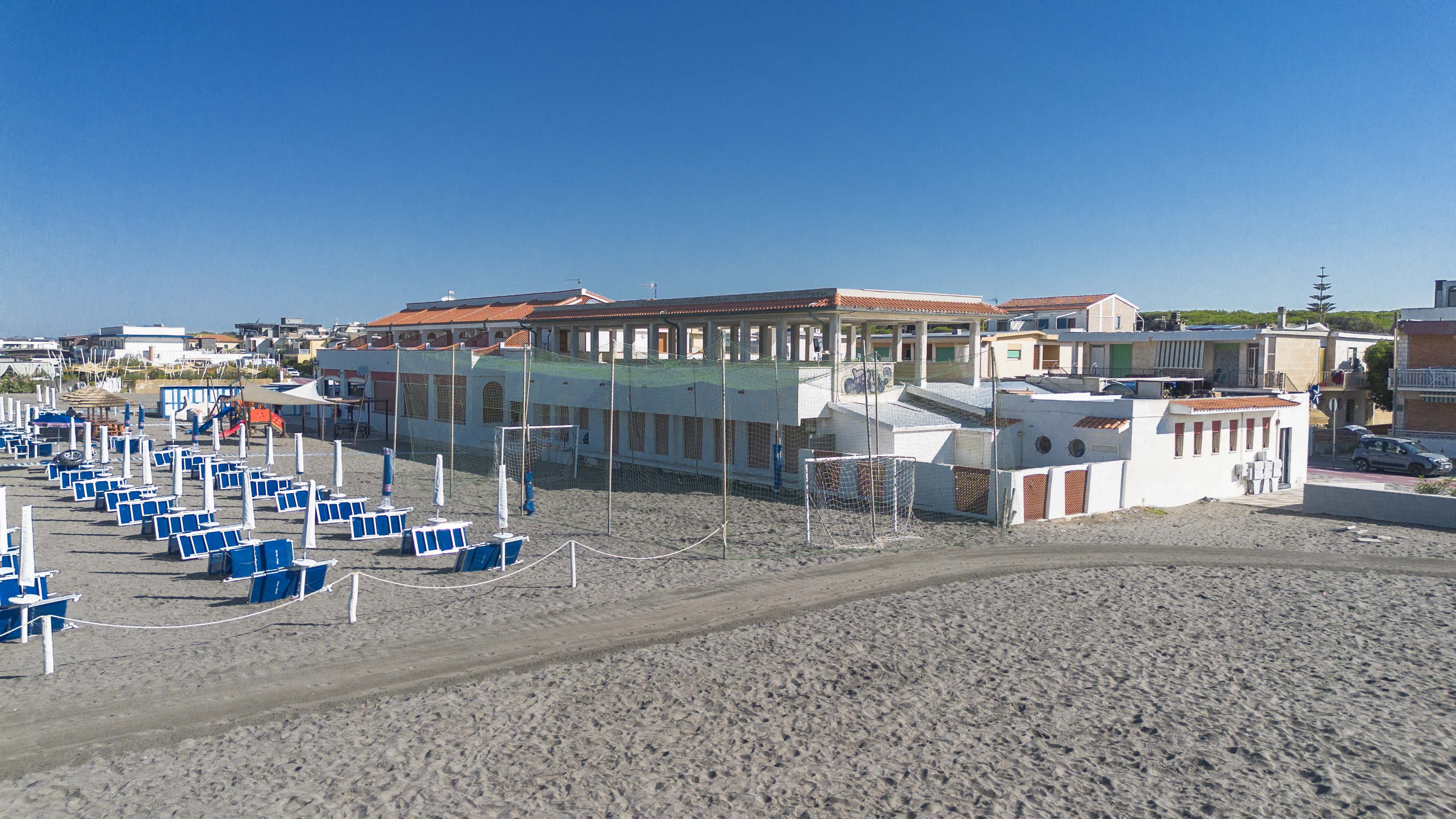 Nota descrizione per utenti visuali: foto fotografica di una spiaggia italiana con strutture di impianto balneare massaggi...